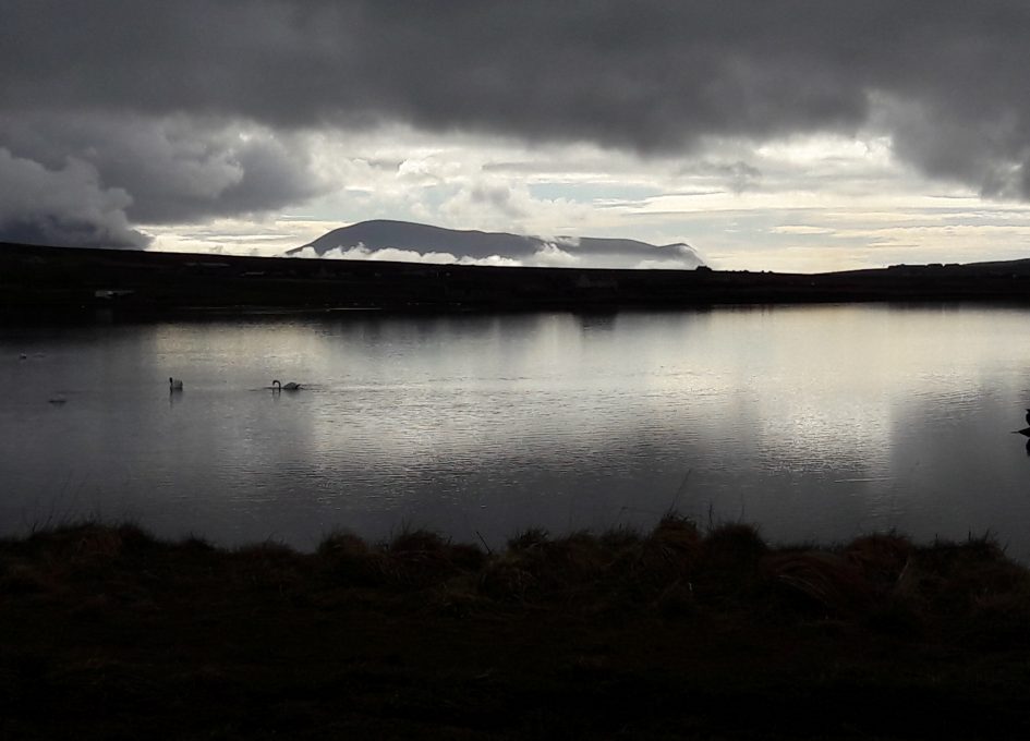 Black and white image of island of Hoy reflected in Loch of Stenness in Orkneys